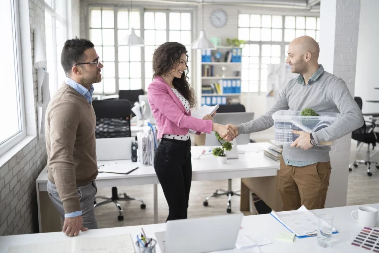 Two colleagues greeting a new team member in an office setting—represents the start of onboarding and the importance of setting up secure access from day one.